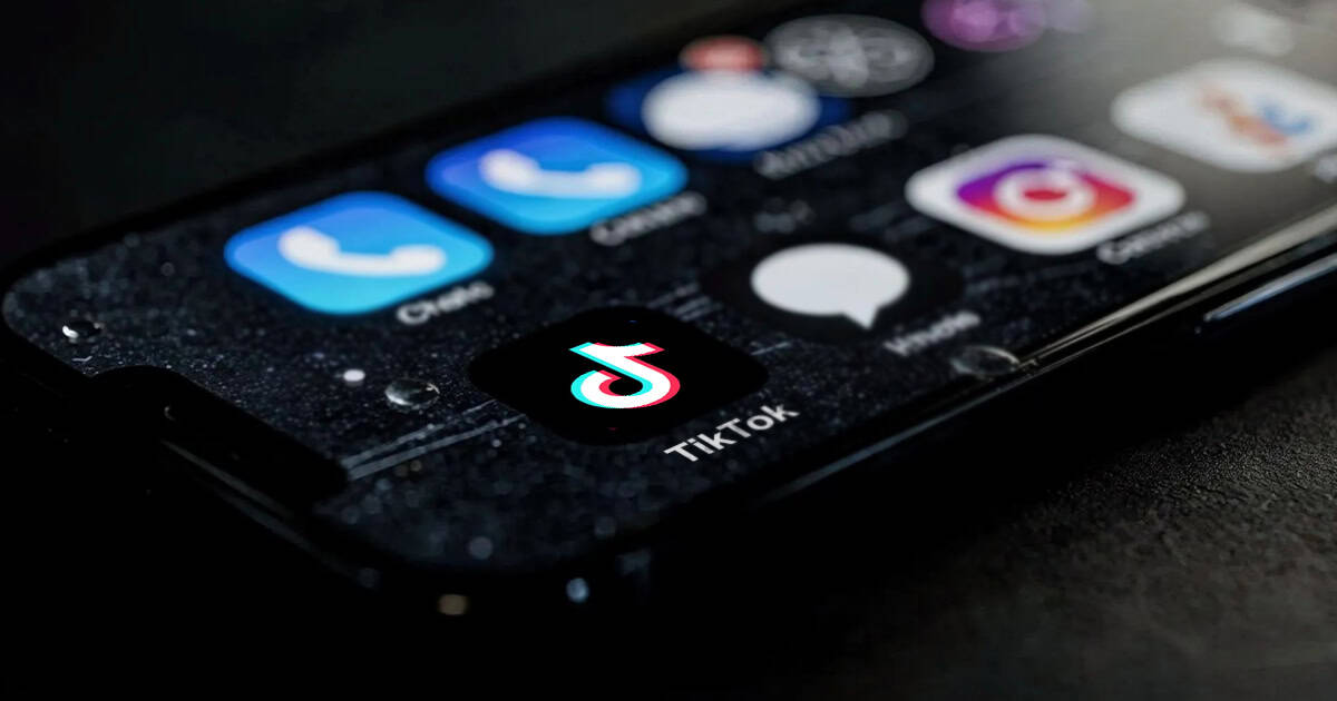 A close-up of a smartphone screen displaying the TikTok app icon among other social media and messaging apps.