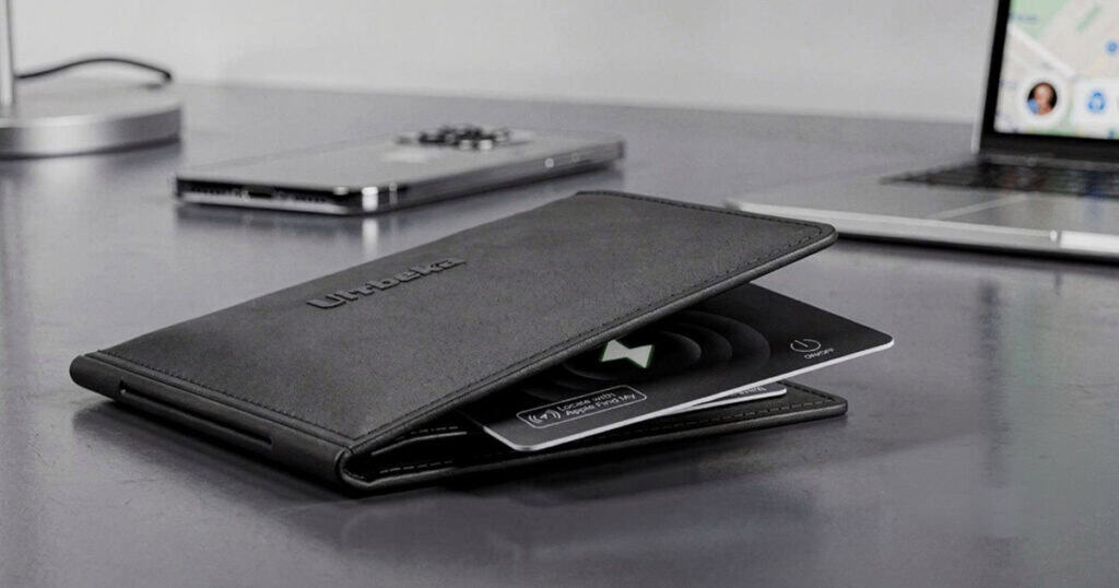 Ultra thin wallet card tracker partially inserted into a leather wallet on a desk
