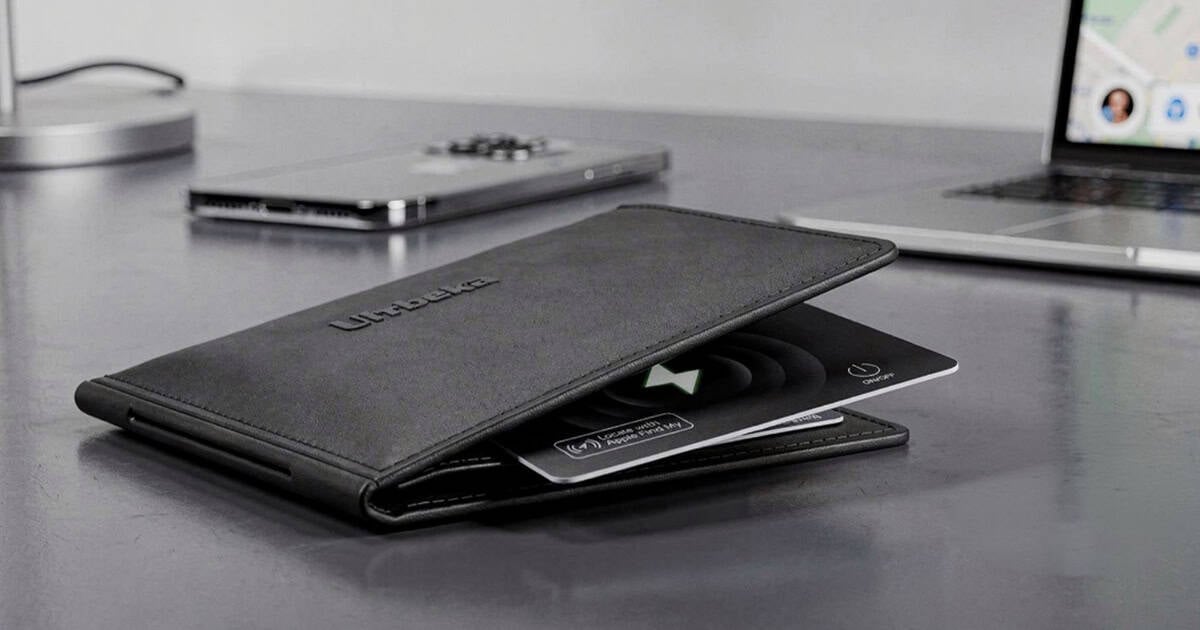 Ultra thin wallet card tracker partially inserted into a leather wallet on a desk